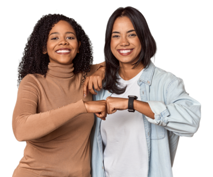 Young Latina friends celebrating with a fist bump