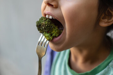 child girl eats with pleasure, food, broccoli, close-up, open mouth,