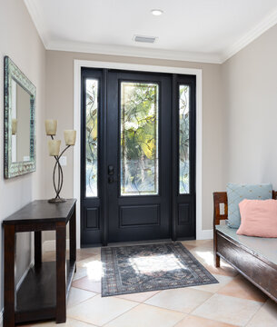 Bright vacation rental foyer with stained glass and bench