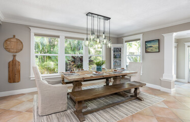 Dining table with wooden bench seat and chandelier in Florida vacation rental home
