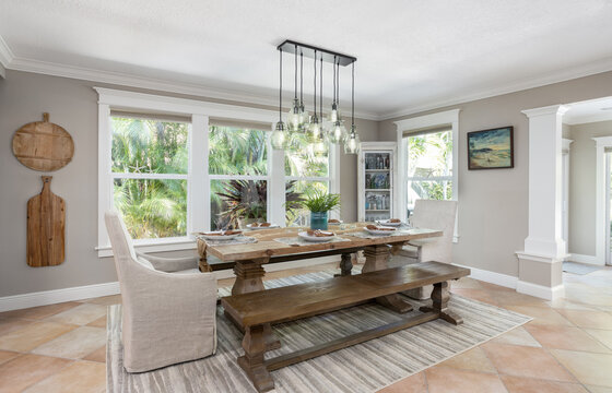 Dining table with wooden bench seat and chandelier in Florida vacation rental home