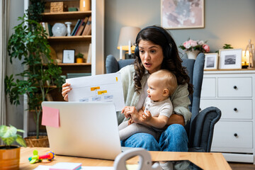 Business woman on maternity leave. Mother with newborn baby working from home using laptop. Female...