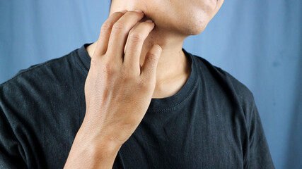 Close up of a man scratching his itchy neck. Health care, skin problems and medical concept.
