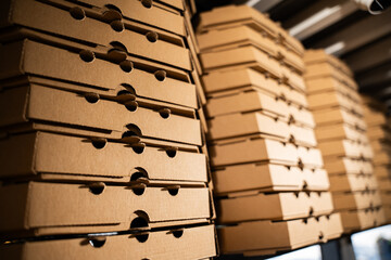 Close-up of a stack of brown pizza delivery boxes.
