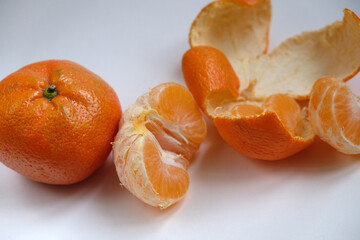 peeled tangerines on white background