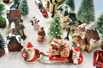 Top view on the street in a small town with two Santa Clauses with Christmas presents on the sledge
