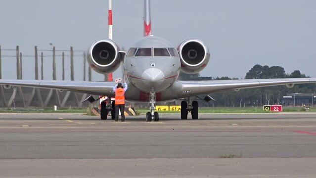 Private Business Corporate Executive Jet arriving at General Aviation Stands at airport with Marshaller