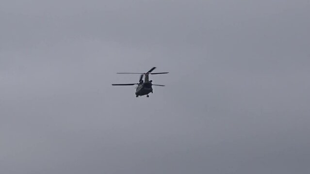Silhouette of Military Chinook Transport Helicopter flying away from camera
