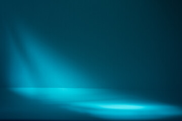 Dark moody stage for products or cosmetics against dark blue background and leaves shadows on the wall.