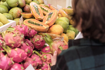 Intrigued by the unique appearance of the dragon fruit, the child's interaction suggests an adventure in trying new and nutritious foods, which can be both educational and fun.