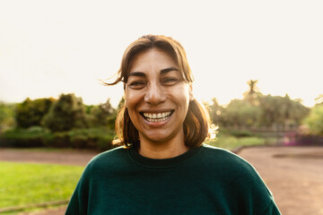 Happy Latin woman having fun smiling in the camera in a public park
