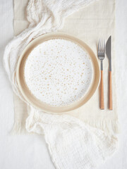table plate setting in beige color, empty plates, fork, knife on linen tablecloth and dishcloth
