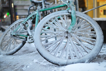 Fototapeta na wymiar green retro bike in ice on a background of snow in winter in a severe frost.