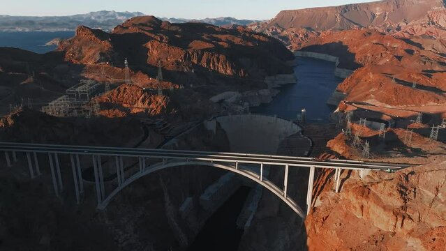 Hoover Dam on the Colorado River straddling Nevada and Arizona at dawn from above. Aerial view of Hoover Dam and the Colorado River Bridge