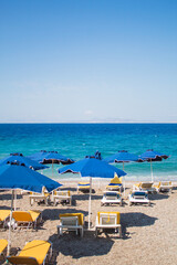 Vacation concept: empty beach with sunbeds and umbrellas, Blue sea in the background. Free copy space