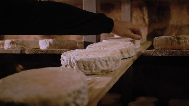 Man Turning A Serra Da Canastra Cheese That Is Being Cured In A Cellar