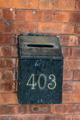 Old and rusty mailbox on a brick wall