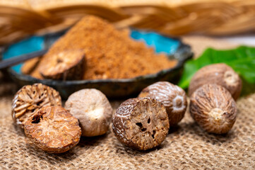 Tasty winter spice whole dried and ground powder nutmeg, used as an ingredient in many dishes, eggnog, potato, mulled wine