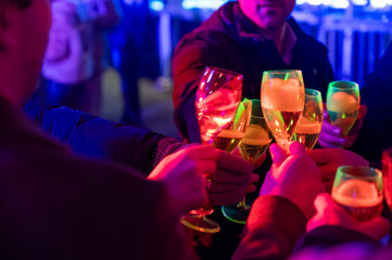Visitors drink of sparkling wine champagne on outdoor winter festival in December on Avenue de...