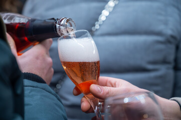 Visitors drink of sparkling wine champagne on outdoor winter festival in December on Avenue de...
