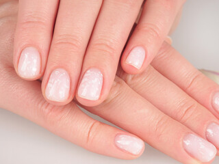 Women's manicure shellac soft pink color close-up