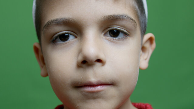 Portrait of cute caucasian boy isolated on green background. High quality photo