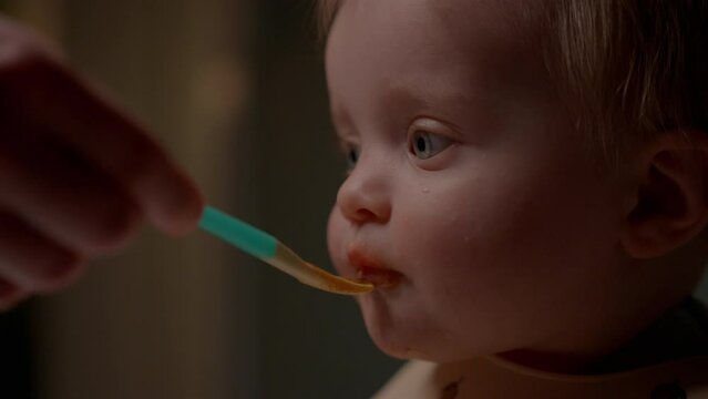 Close-Up Of Baby Chewing While Being Spoon-Fed