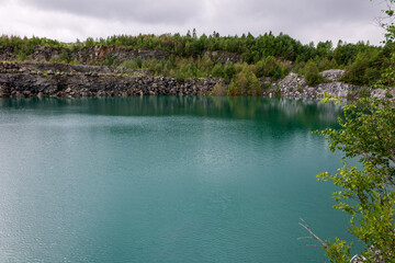 Cold mountain lake with clean transparent water, Northern quarry pond wide