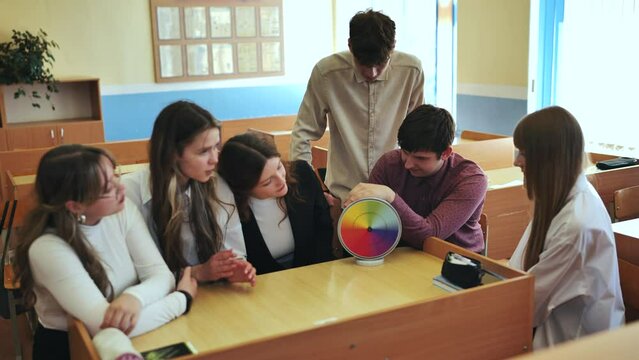 Students in physics class spin Newton's colorful wheel.
