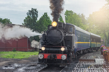 Fototapeta na wymiar Retro steam train approaches to the platform.