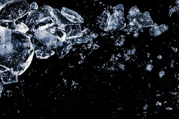 Ice shards crush on a black background. Chill backdrop.