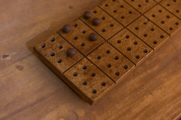 Wooden braille board with marbles resting on a wooden surface. Braille concept