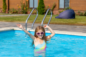 Cute little girl in swimming pool on sunny day. Space for text