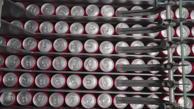 The moment when filled tin cans move along the production line in a fully automated bottling plant