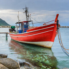 Fototapeta na wymiar Red fishing boat moored and waiting for the next catch
