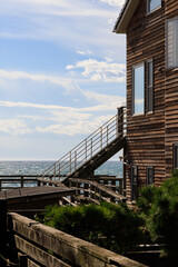 海辺にある茶色の木造の建物、海に続く階段