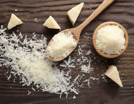 Grated Parmesan Cheese In Spoon Isolated On White Background, Top View