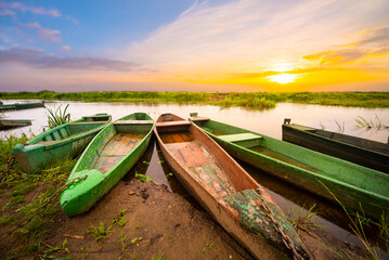 Zachód słońca na rzece z łodziami