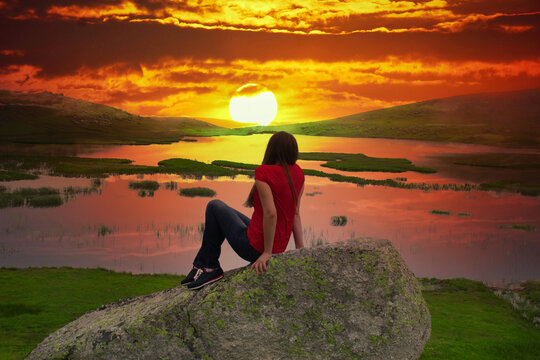 Young girl watching the foggy valley and lake. Magnificent nature view with fog and sun..