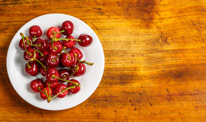 Red cherry berries on a wooden surface, red berry