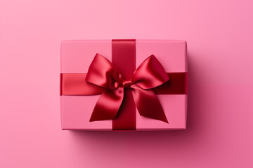 Gift or present for birthday, Valentines Day or Mothers Day. Beautifully decorated giftbox with ribbon bow isolated on pink background.