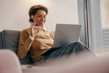 Positive female freelancer have online meeting while sitting in cozy coworking during working day