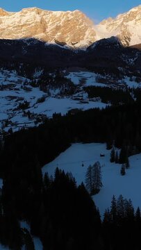 Sas dla Crusc Mountain. Dolomite Alps in Winter at Sunset. Badia, South Tyrol, Italy. Aerial View. Drone Flies Forward, Tilt Up. Reveal Shot. Vertical Video