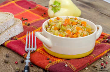 Bowl with hot vegetable stew with zucchini on a napkin