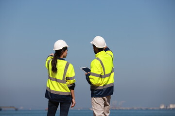 two projects engineer discussion at the coastline near the refinery 