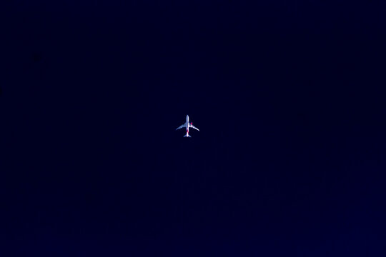 Airliner flying in the night sky, closeup of photo