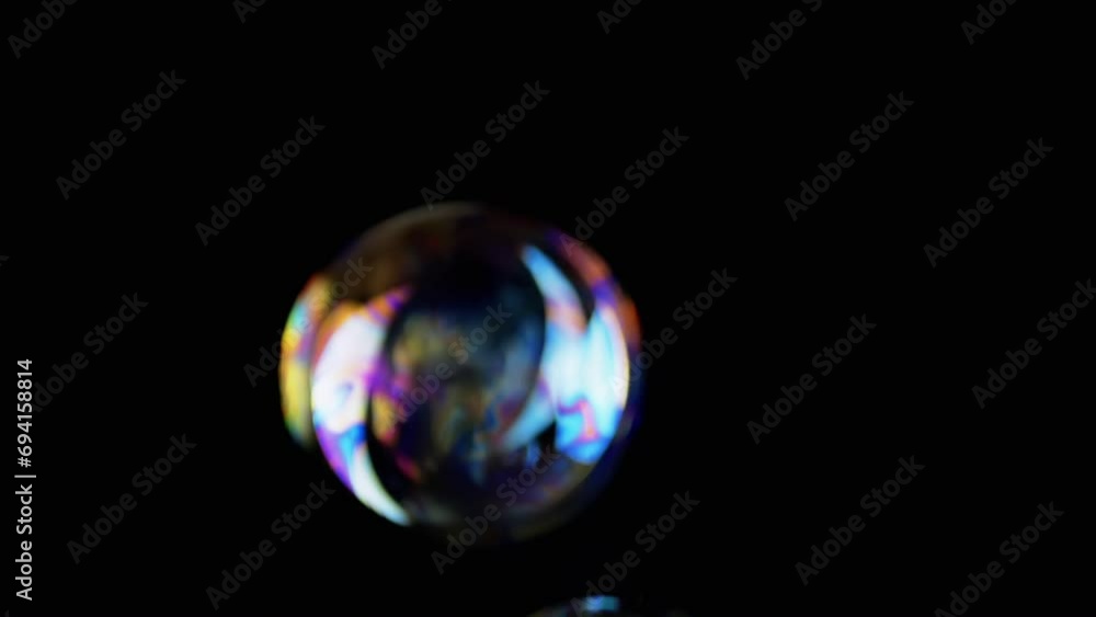 Poster lot of large colorful soap bubbles fly on a black background in empty space. close up. vibrating tra