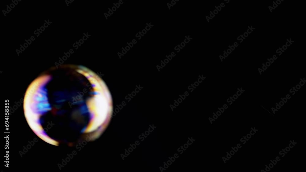 Poster lot of large colorful soap bubbles fly on a black background in empty space. blowing. foam. liquid s