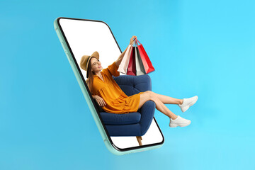 Online shopping. Happy woman with paper bags in armchair looking out from smartphone on light blue background