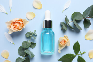 Flat lay composition with cosmetic serum on light blue background